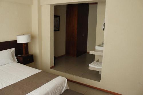 底拉斯卡拉Hotel Tlaxcala的酒店客房,配有床和镜子