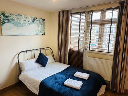 伦敦London Mackenzie Apartment的一间卧室配有一张床,上面有两条毛巾