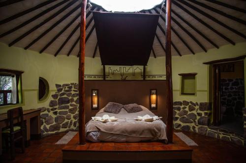 CoporaqueAyni Wasi的卧室配有一张位于房子内的天蓬床