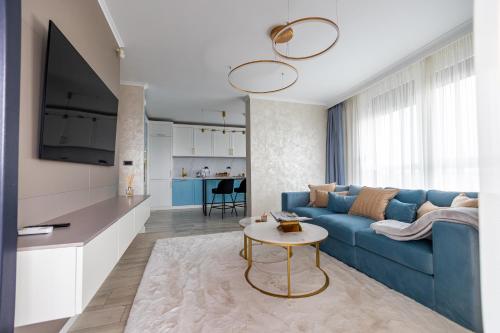 阿拉德Arad Residence - DeLuxe Blue Apartment的客厅配有蓝色的沙发和桌子