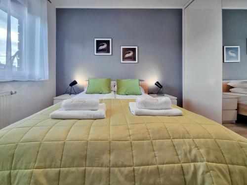 雷达CLASSY APARTMENTS - AQUAPARK Reda的一间卧室配有一张带绿色枕头的大型黄色床
