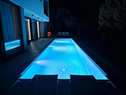 锡尼Villa Lapidea的夜间房子中间的一个游泳池