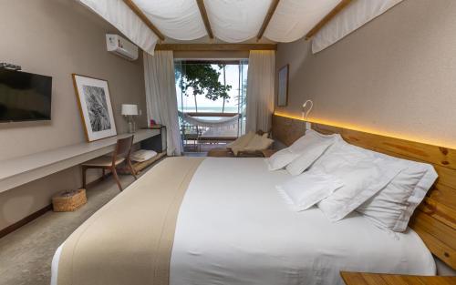 马塞约Flor de Lis Exclusive Hotel的卧室配有一张白色大床和一张书桌