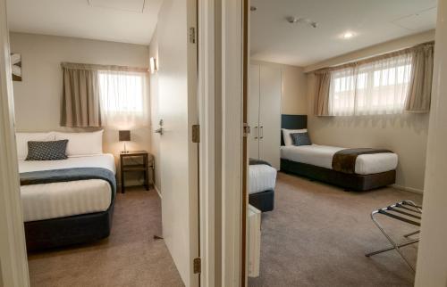 朗伊奥拉The Riverstone的一间酒店客房,设有两张床和走廊