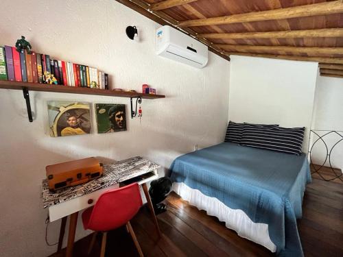 伦索伊斯Chalés Calima的一间卧室配有一张床和一张带键盘的书桌