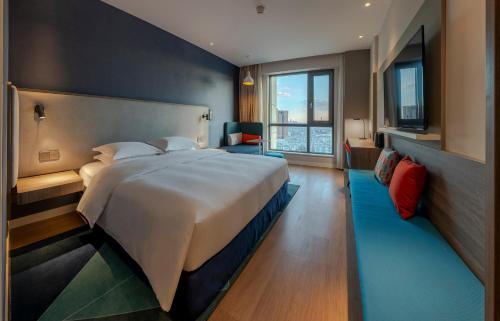 昆明昆明西部智选假日酒店的一间卧室设有一张大床和一个大窗户