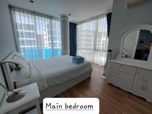 华欣Light, airy, pool views 2 bed 2 bath, free wifi, elect的一间卧室配有一张大床和镜子