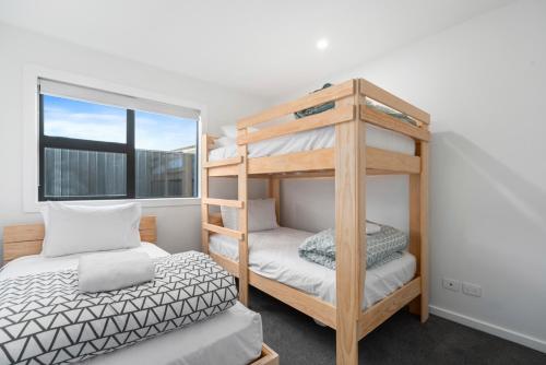 陶波CatchN'Relax Taupo的一间卧室设有两张双层床和一扇窗户。