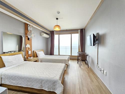 济州市Red Castle Pension的酒店客房设有两张床和窗户。