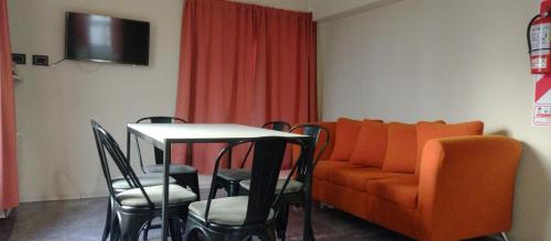 埃尔卡拉法特Departamento DON ALBERTO的客厅配有橙色的沙发、桌子和椅子