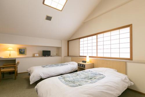 十日町Ryounkaku Matsunoyama onsen的带窗户的客房内的两张床
