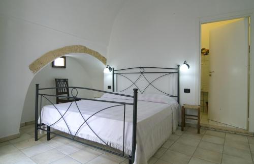 帕拉比塔B&b Altrov'è的一间卧室设有一张床和一个拱形门廊