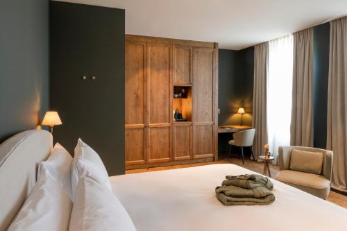 德哈恩Hotel des Brasseurs的卧室配有白色的床和书桌