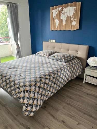 永河畔拉罗什Charmant appartement la Roche sur Yon的卧室内的一张床铺,卧室内有蓝色的墙壁