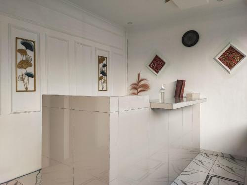 SarolangunRedDoorz Syariah at Naffa Homestay的白色的房间,设有柜台和架子
