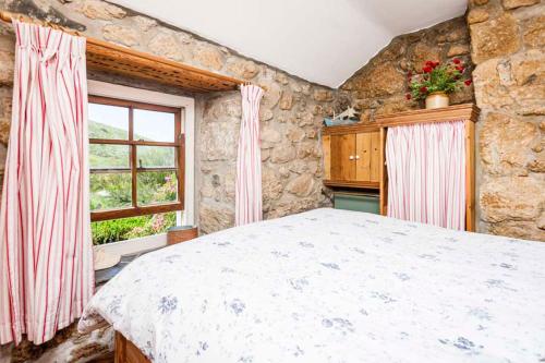 森嫩White Rose, Cornish Cottage With Sea Views & Private Garden By Beach的一间卧室设有一张大床和一个窗户。