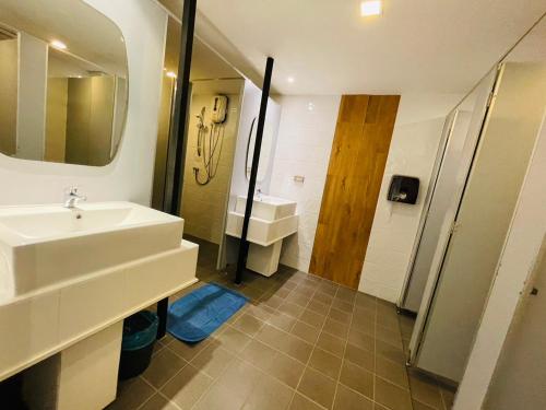 普吉镇Rabbitel Phuket的一间带水槽、镜子和淋浴的浴室