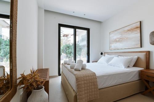 米提卡斯Melior Luxury Villas的一间卧室设有一张床和一个大窗户