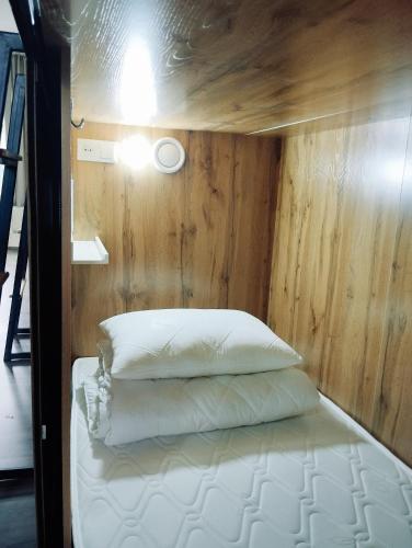 比什凯克Salma Capsule Hostel的木墙客房的一张床位