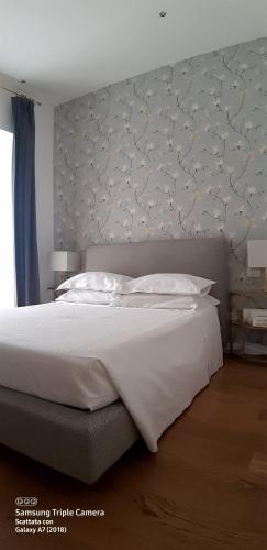 罗马威尼斯广场公寓及露台的卧室配有一张白色大床和床头板