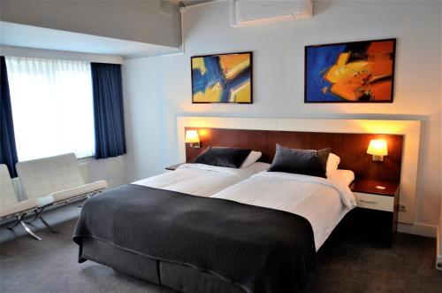 奈梅亨阿波罗酒店的一间卧室设有两张床、一张桌子和窗户。