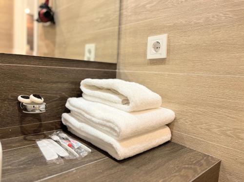 阿拉木图Resident Hotel Gogol的浴室的台面上摆放着一堆毛巾