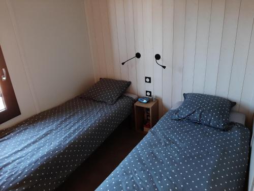瑞卢维尔莱潘Cottage的卧室设有两张单人床,配有蓝色床单