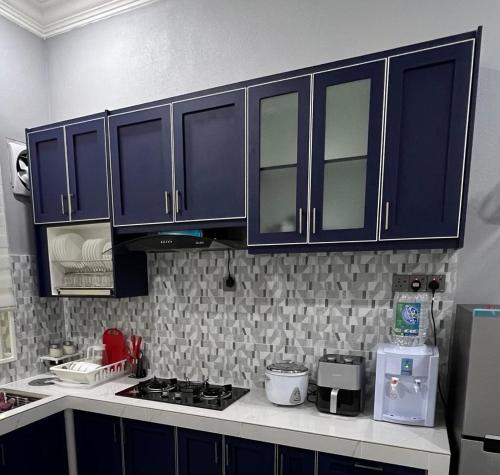 巴西富地Majestic Homestay - Pasir Puteh的厨房配有蓝色橱柜和台面