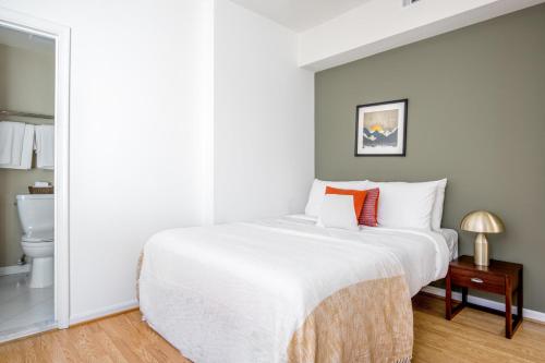 华盛顿Dupont Circle 1BR nr U St Metro Glens Mkt WDC-193的卧室配有带橙色枕头的大型白色床