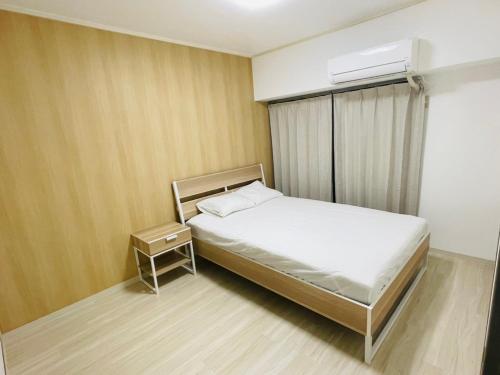KusugaurachōASUKA HINODECHO ｌ日の出町的一间小卧室,配有一张床和空调