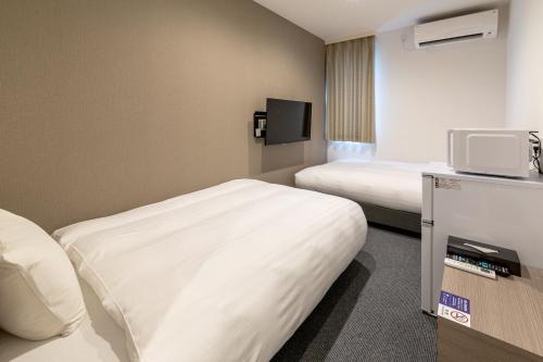 津山市HOTEL R9 The Yard Tsuyama的一间酒店客房,设有两张床和电视