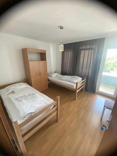 普里什蒂纳Hostel Heimli的一间卧室设有两张床和大窗户