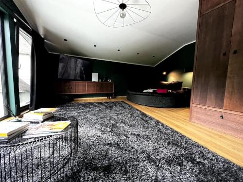 PriedkalneBLACK HOUSE - premium holiday guest house的一间设有大地毯和天花板的客厅