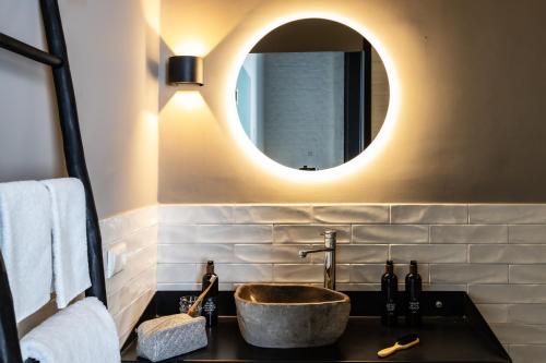登博斯KASerne Boutique Hotel的一间带水槽和镜子的浴室