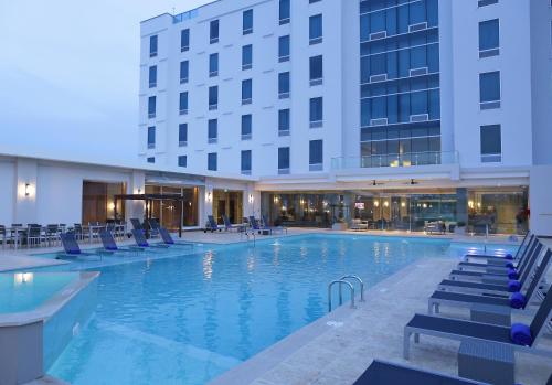 Tocumen机场皇冠酒店的酒店游泳池设有椅子,酒店大楼