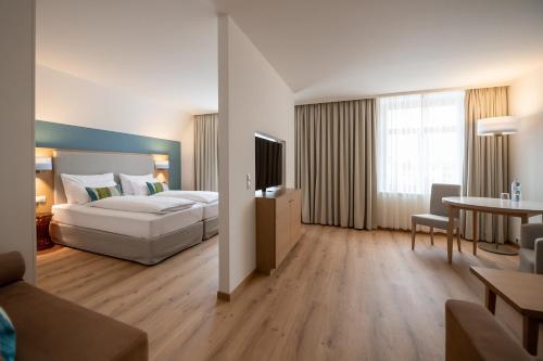 洛豪Seehotel am Kaiserstrand的大型酒店客房设有一张床铺和一张桌子。