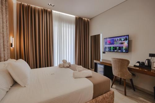 卡萨米尔The Lord Hotel的酒店客房配有一张床、一张书桌和一台电视。