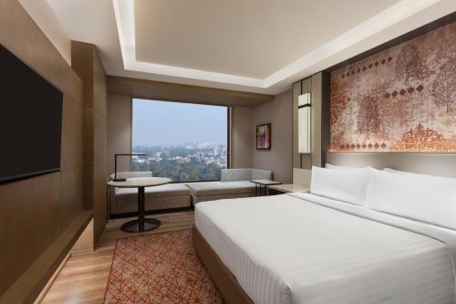 阿姆利则Courtyard by Marriott Amritsar的酒店客房,配有床和沙发