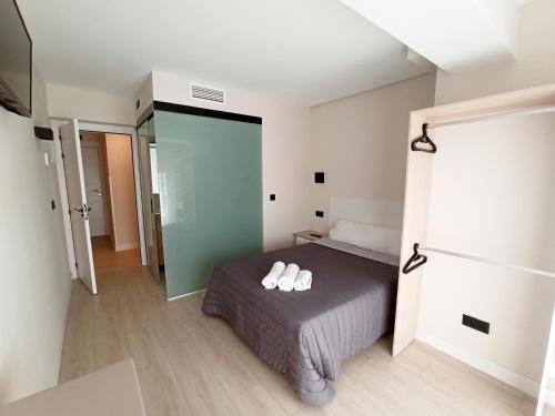 桑坦德Bahia Rooms Cantabria 3000的一间卧室,床上有两双白鞋