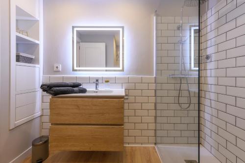 穆尔西亚Apartamento Suite Gran Vía的一间带水槽、镜子和淋浴的浴室