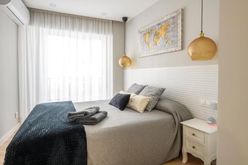 穆尔西亚Apartamento Suite Gran Vía的一间卧室配有一张床,上面有两条毛巾