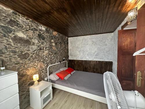 阿格特Casa Álamo Agaete的一间卧室设有一张床和石墙