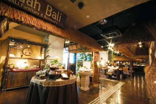 千叶BaliAn Resort Chiba-Chuo的大楼内带桌子的餐厅和酒吧