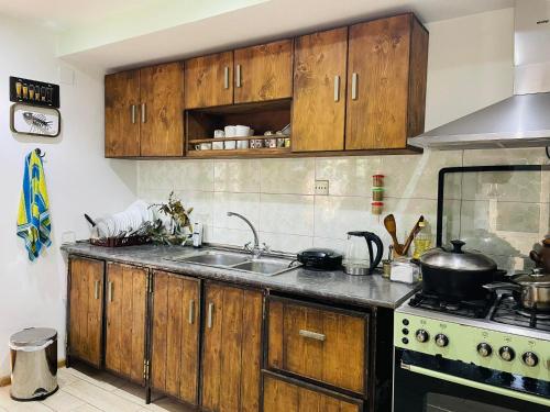 拉戈代希Guest House OLD WALL的厨房配有木制橱柜、水槽和炉灶。