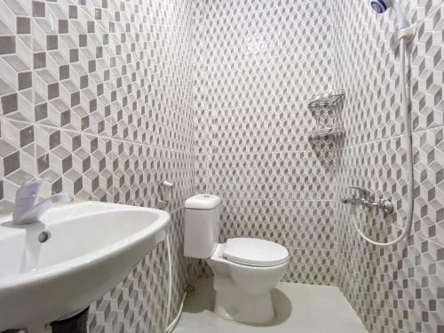 SagulungRedDoorz @ Cikitsu Batam的白色的浴室设有卫生间和水槽。