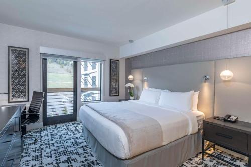 弗瑞斯科Cambria Hotel Copper Mountain的酒店客房设有一张大床和一台电视。