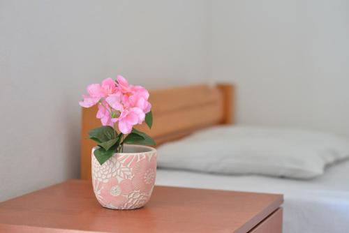 乐托卡亚Studio's Stelios的坐在桌子上的花瓶里,粉红色的花