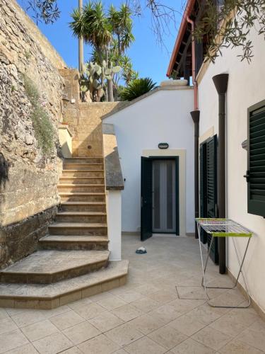 莱乌卡Villa Romana的通往带黑色门的房子的楼梯