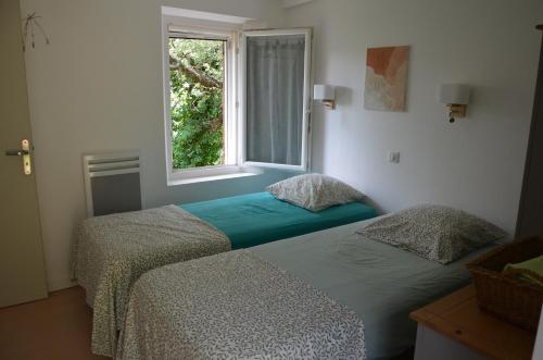 科洛布里埃Gîte Almanda - Calme & Nature - Mas Lou Castanea的带窗户的客房内的两张床