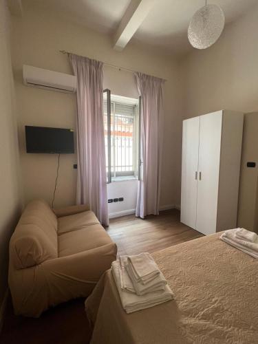 雷焦卡拉布里亚ReggioDuomo的一间卧室配有一张床、一张沙发和一个窗口